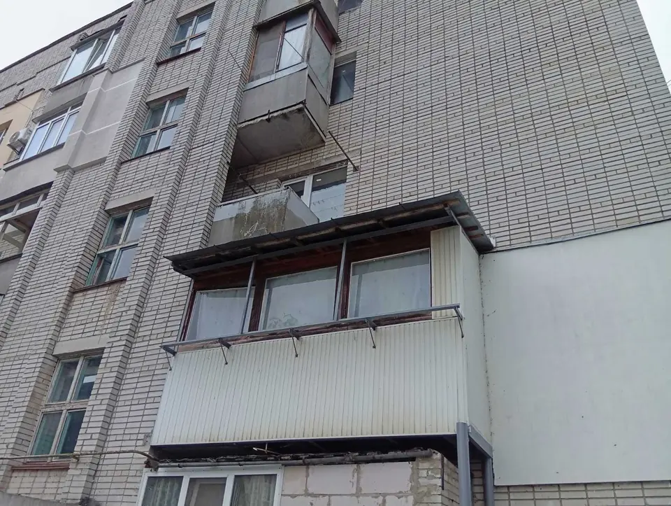 Балкон на другому поверсі цегляної п'ятиповерхівки: змонтовано винос на кронштейнах, дах і обшивку — перед заміною засклення